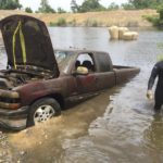 Chevrolet 1500 on the bank. Cadillac (floating in background) ready for removal.