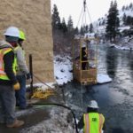 Personnel clearing icicles from building